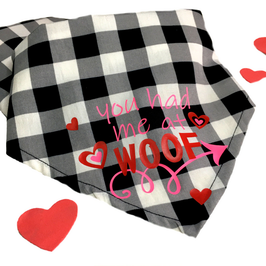 black and white checked dog bandana with pink and red lettering and hearts.  "you had me at woof"